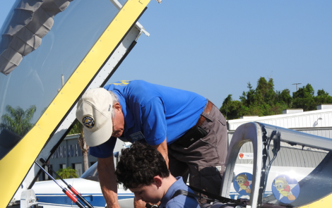 7372 EAA Chapter 534 pilot Steve Tilford gets Young Eagle Luke Naylor buckled in for his flight.