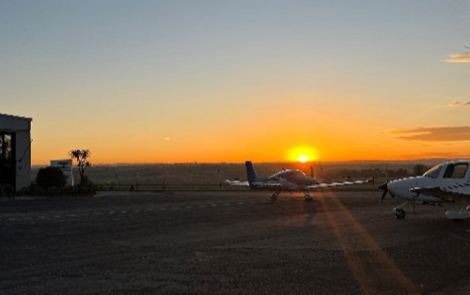 Sunset at an airfield with planes